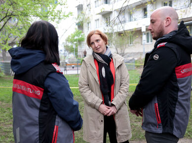 Zwei Ordnungsberater*innen von hinten im Gespräch mit Elke Hanel-Torsch, der Wohnbaustadträtin.