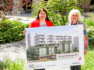 Vizebürgermeisterin Kathrin Gaal hält gemeinsam mit der Bezirksvorsteher-Stellvertreterin des dritten Bezirks, Susanne Wessely eine Tafel, die eine Visualisierung des Gemeindebau NEU im Village im Dritten zeigt.