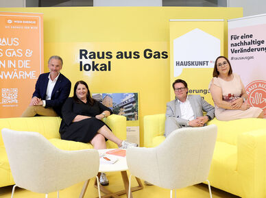 (v.l.n.r.): Baudirektor Bernhard Jarolim, Vizebürgermeisterin Kathrin Gaál, Klimastadtrat Jürgen Czernohorszky, Bezirksvorsteher Stellvertreterin Julia Lessacher. Gaál und Czernohorszky sitzen jeweils auf einer gelben Ledercouch, auf deren Rückenlehnen Jarolim und Lessacher sitzen. Jarolim trägt eine helle Hose, weißes Hemd und einen dunkelblauen Blazer, Gaál ein schwarzes Kleid, Czernohorszky einen hellgrauen Anzug mit weißem Hemd, Lessacher ein beiges Kleid.